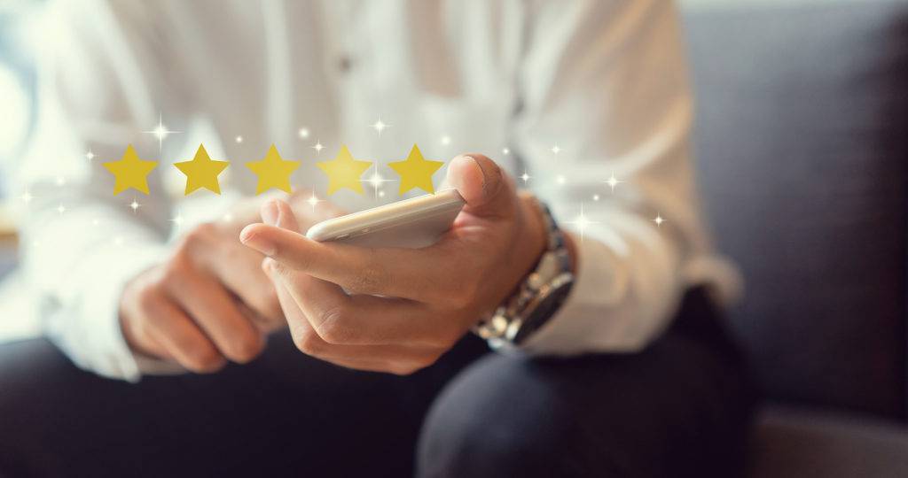 Person Holding Phone with Star Ratings